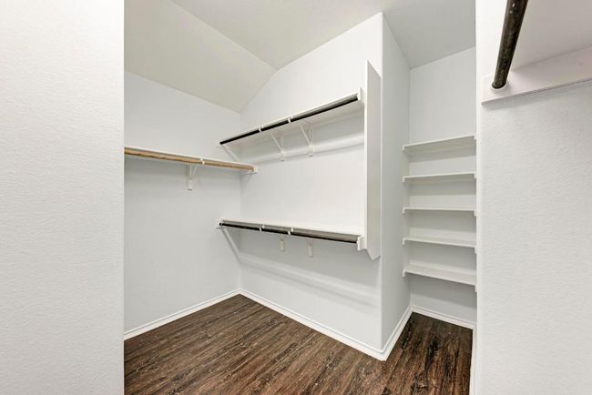 Walk in closet featuring dark wood-type flooring and lofted ceiling | Image 25