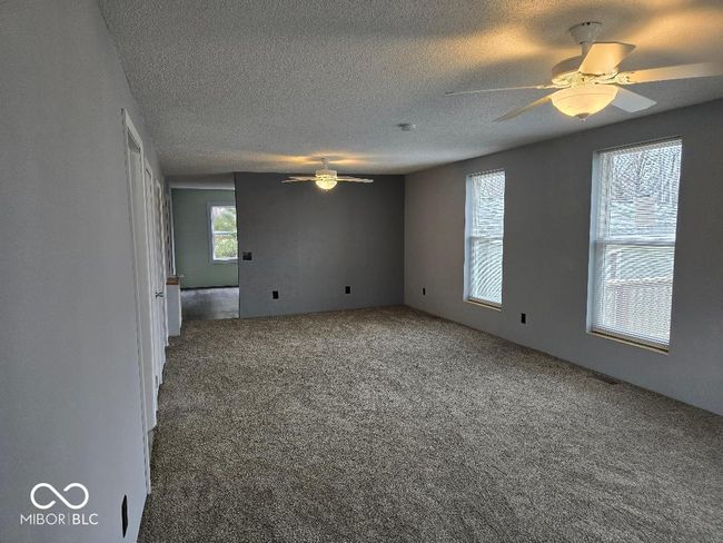 carpeted empty room featuring a textured ceiling and ceiling fan | Image 30