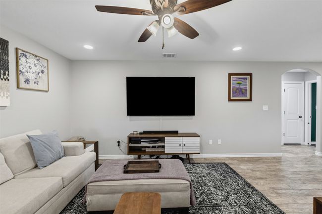 Living area with arched walkways, baseboards, ceiling fan, and recessed lighting | Image 9