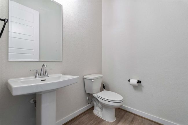 Bathroom featuring toilet, baseboards, and wood finished floors | Image 16