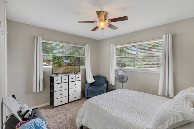 Bedroom with light carpet, ceiling fan, and baseboards | Image 12