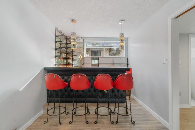 Bar featuring a dry bar, a textured ceiling, baseboards, and wood finished floors | Image 30