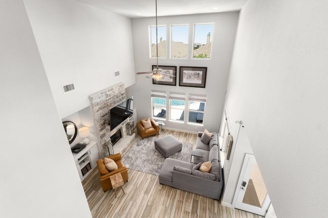View of living room from the game room featuring light wood-style flooring, a towering ceiling, and a fireplace | Image 27