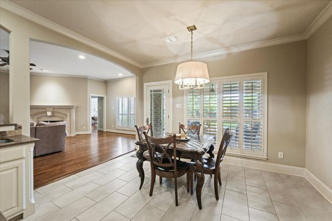 Breakfast area featuring a chandelier, crown molding, baseboards, arched walkways, and light tile patterned floors | Image 16