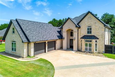 French country inspired facade featuring a garage and a front yard | Image 2