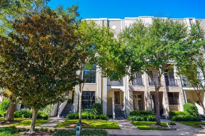 Impressive three-story townhouse features large windows and two balconies on the second floor. Enjoy mature trees and well-maintained landscaping, offering both shade and curb appeal. . | Image 2