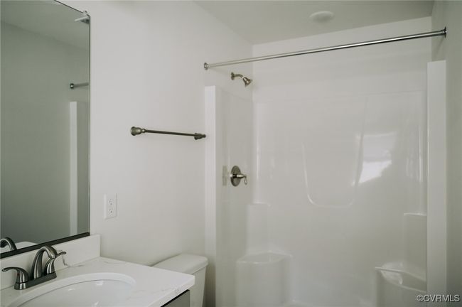 Bathroom featuring toilet, a shower, and vanity | Image 13