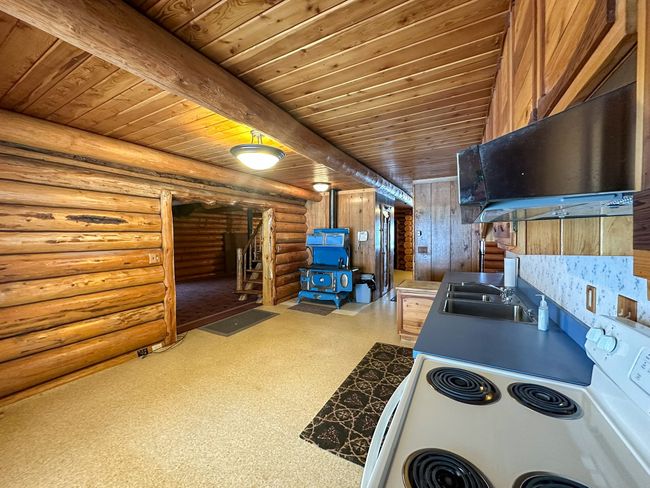 Kitchen with sink, a wood stove, electric range, and wood ceiling | Image 26