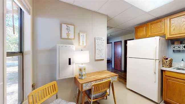 Kitchen featuring freestanding refrigerator, a paneled ceiling, and light countertops | Image 5