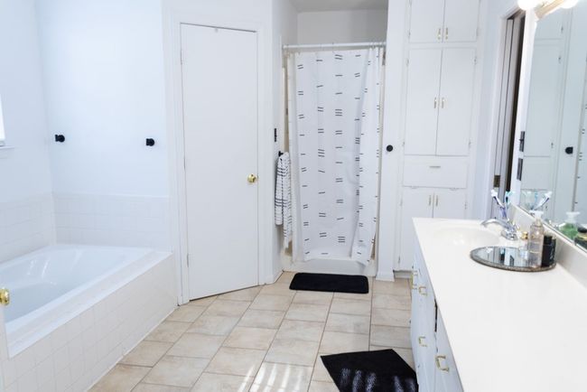 Bathroom featuring vanity, a garden tub, a shower with shower curtain, and tile patterned floors | Image 17