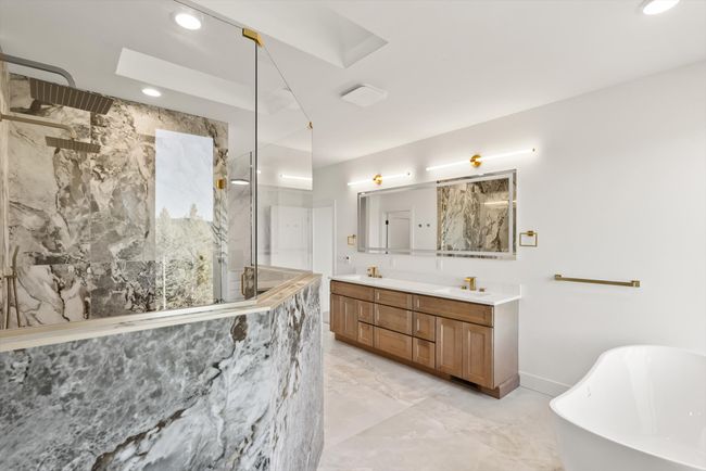 Spa-like Primary Bathroom with large picture windows, skylights, tub, large shower, double vanity and heated tile floor | Image 32