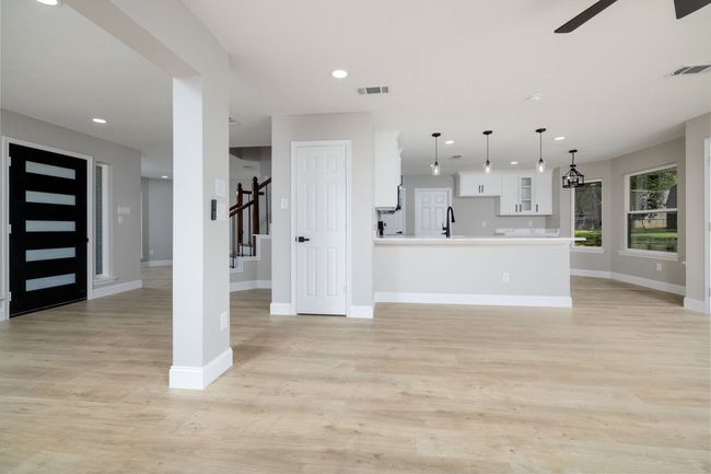 Unfurnished living room with a ceiling fan, light wood finished floors, and recessed lighting | Image 11