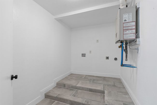 Washroom featuring hookup for an electric dryer, water heater, and washer hookup | Image 25