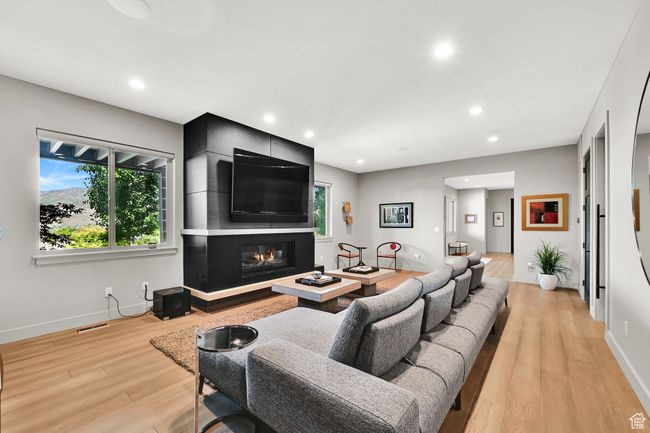 Living room with light wood-style floors, a fireplace, baseboards, and recessed lighting | Image 36