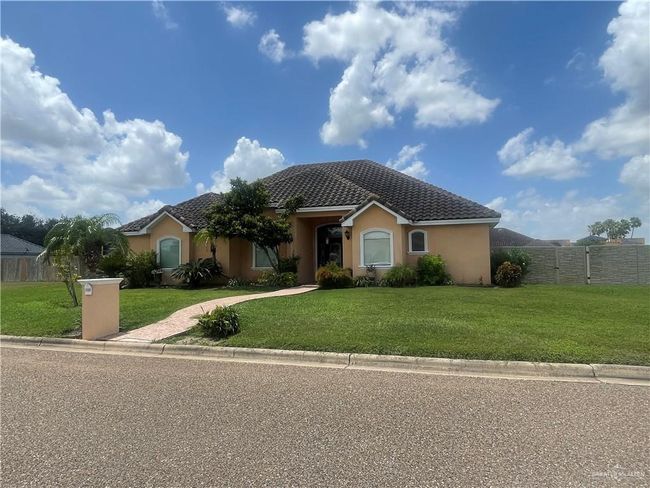 Single story home with stucco siding, a tiled roof, and driveway | Image 18