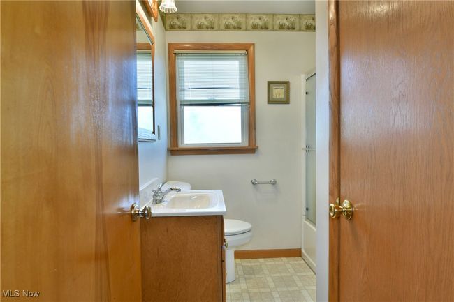Bathroom featuring tile patterned floors, vanity, baseboards, toilet, and shower / bath combination with glass door | Image 29