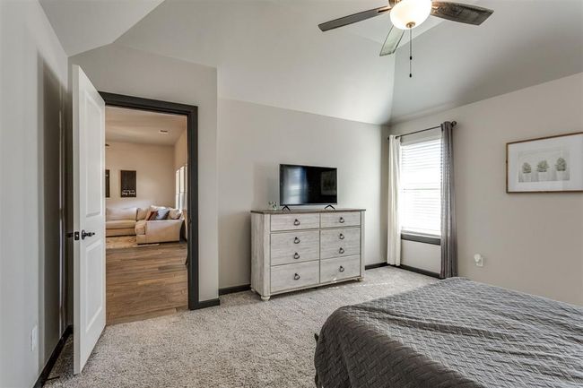 Carpeted bedroom with vaulted ceiling, baseboards, and ceiling fan | Image 22