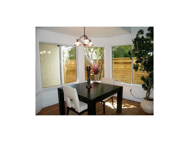 Dining room featuring a chandelier, wood finished floors, and plenty of natural light | Image 22
