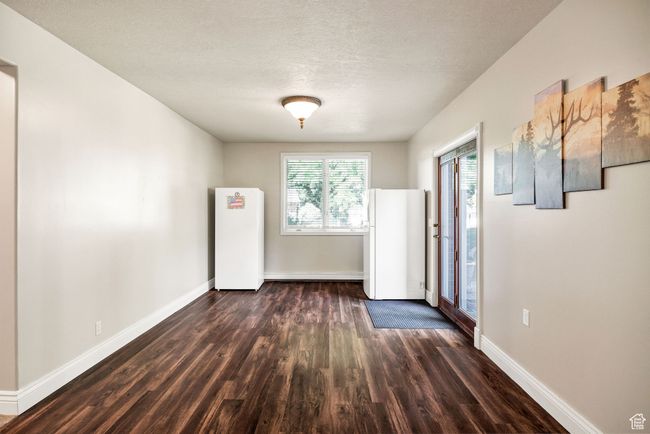 Unfurnished room with dark wood finished floors and a textured ceiling | Image 61