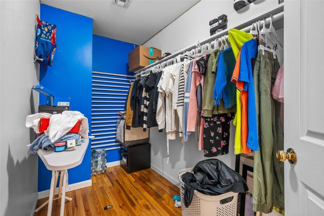 Walk in closet featuring visible vents and wood finished floors | Image 28