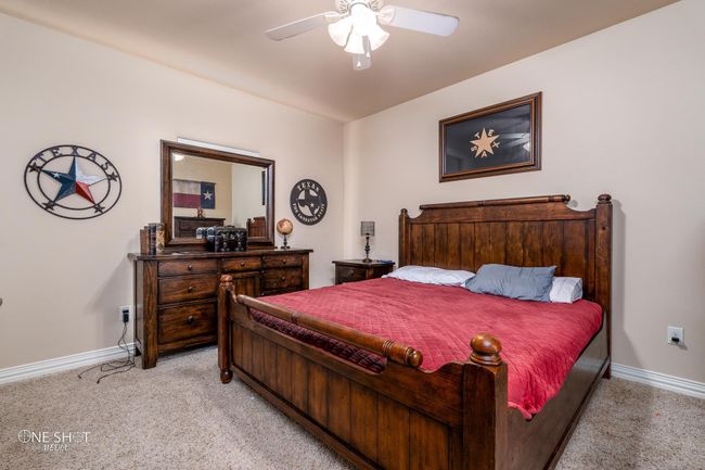 Bedroom featuring light colored carpet, baseboards, and a ceiling fan | Image 26