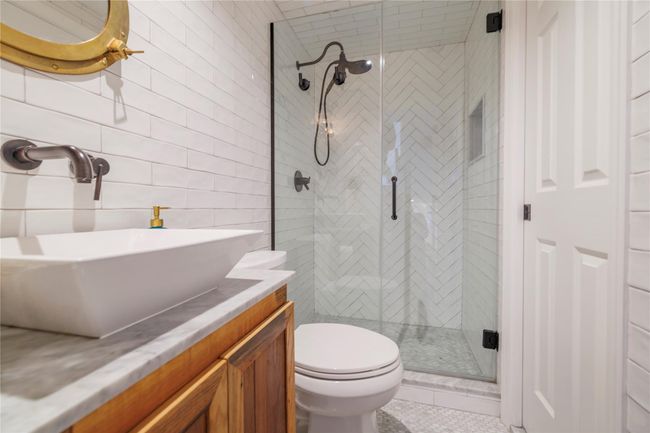 Full bathroom featuring tile walls, a shower stall, toilet, vanity, and tasteful backsplash | Image 10