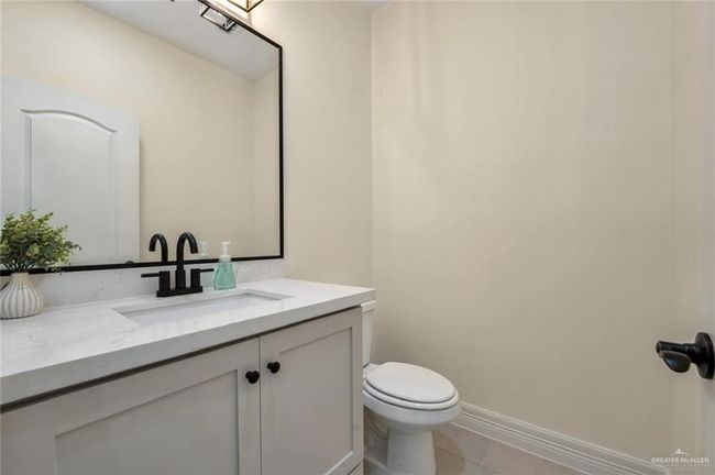 Half bath featuring vanity, toilet, tile patterned flooring, and baseboards | Image 18