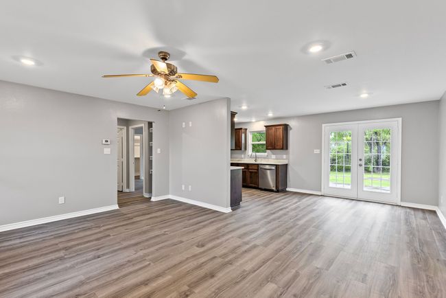 Unfurnished living room with ceiling fan, wood finished floors, and recessed lighting | Image 6
