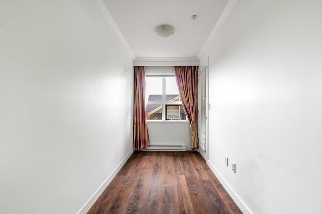 Spare room with crown molding, baseboard heating, and dark wood-type flooring | Image 12