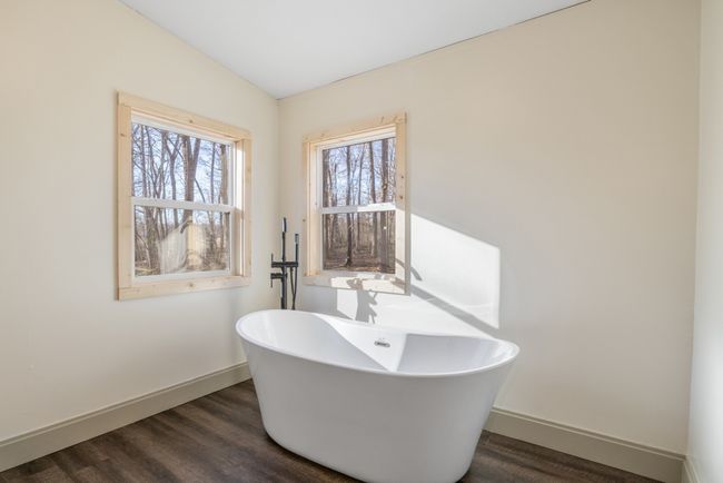 The en-suite bath overlooks the wooded backyard, creating a spa-like ambiance perfect for unwinding. | Image 14