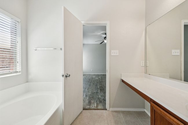 Bathroom featuring plenty of natural light, a bath, ceiling fan, and vanity | Image 18
