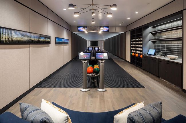 Recreation room with bowling, wood finished floors, and a notable chandelier | Image 20