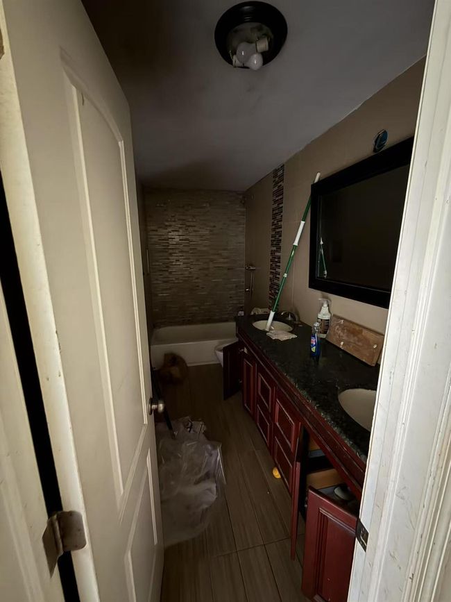 Full bath with a tub to relax in, double vanity, and wood finished floors | Image 5