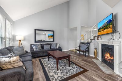 Living room with high vaulted ceiling and wood-type flooring | Image 1