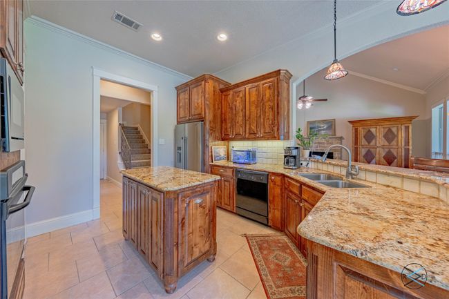 Kitchen with vaulted ceiling, black appliances, backsplash, hanging light fixtures, and sink | Image 21