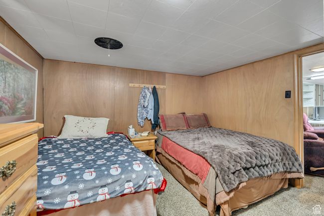 Bedroom with carpet flooring and wood walls | Image 23