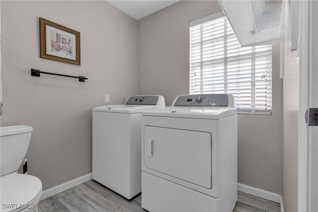 Laundry area featuring washing machine and clothes dryer, laundry area, and baseboards | Image 20