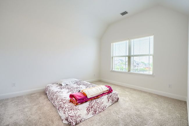 Carpeted bedroom with vaulted ceiling, visible vents, and baseboards | Image 27