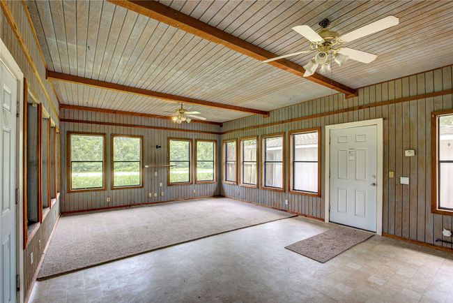 Unfurnished Bonus Room featuring tile patterned floors, wood walls, and beamed ceiling | Image 16