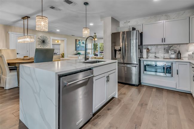 Kitchen featuring appliances with stainless steel finishes, a chandelier, recessed lighting, pendant lighting, and light wood-style flooring | Image 12