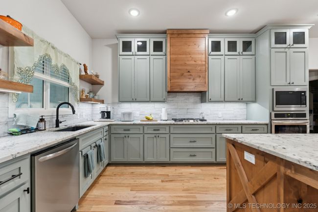Custom vent hood, and it matches the custom decorative piece above the island. | Image 10