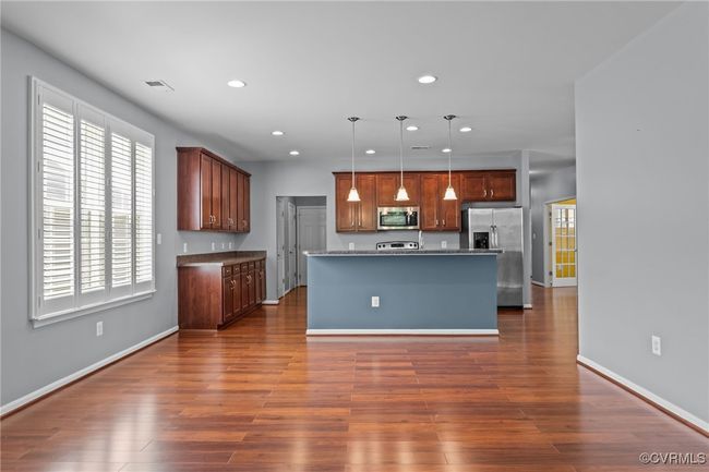 Kitchen featuring stainless steel appliances, recessed lighting, dark wood-style flooring, hanging light fixtures, and a center island | Image 8