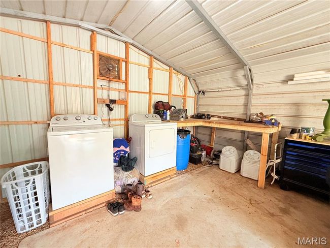 Garage featuring washer and dryer and a workshop area | Image 23