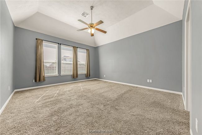 Carpeted spare room featuring lofted ceiling and ceiling fan | Image 24