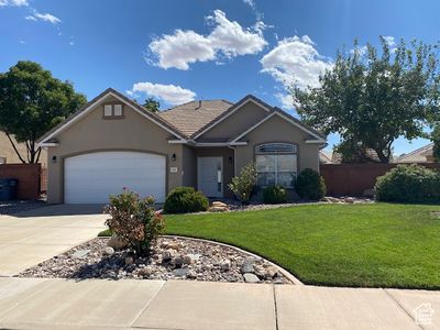 Ranch-style house with a front lawn and a garage | Image 1