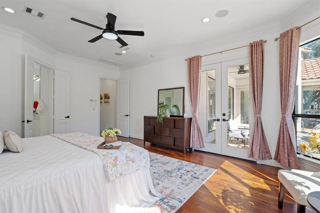 Additional view of the primary bedroom suite, highlighting the inviting bay window and serene pool view. Crown molding and high ceilings add sophistication, while private double-door access to the backyard enhances indoor-outdoor living. | Image 20