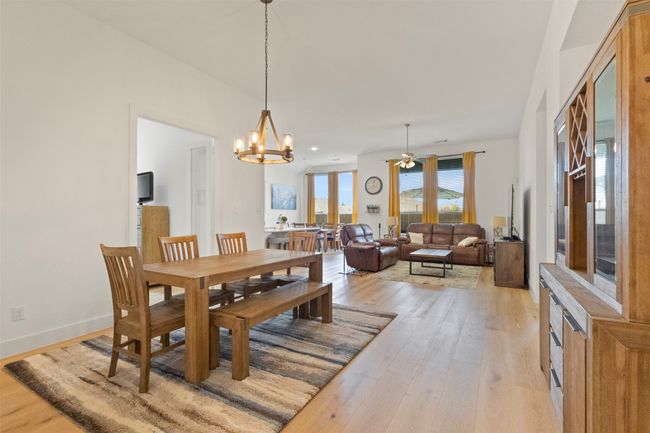Dining area with light wood-style floors and a chandelier | Image 16