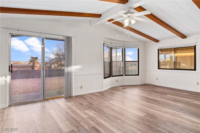 Dining area with vaulted ceiling with beams, wood style floors, and a ceiling fan | Image 14