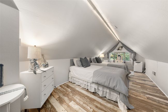 Bedroom featuring wood finished floors and lofted ceiling with extra sleeping quarters | Image 23