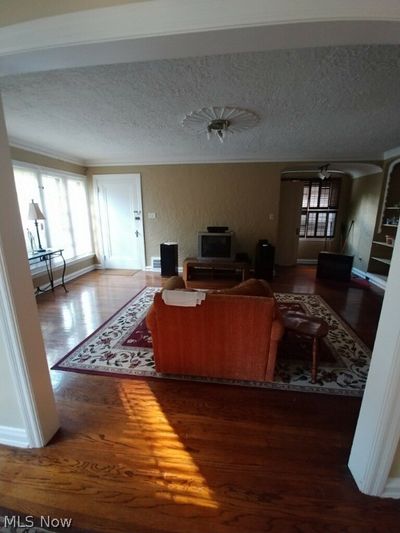 Living room with dark hardwood / wood-style floors and a textured ceiling | Image 3